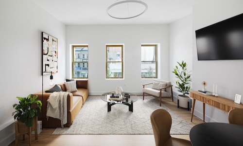 Spacious and well lit living room with wood floors and large windows 